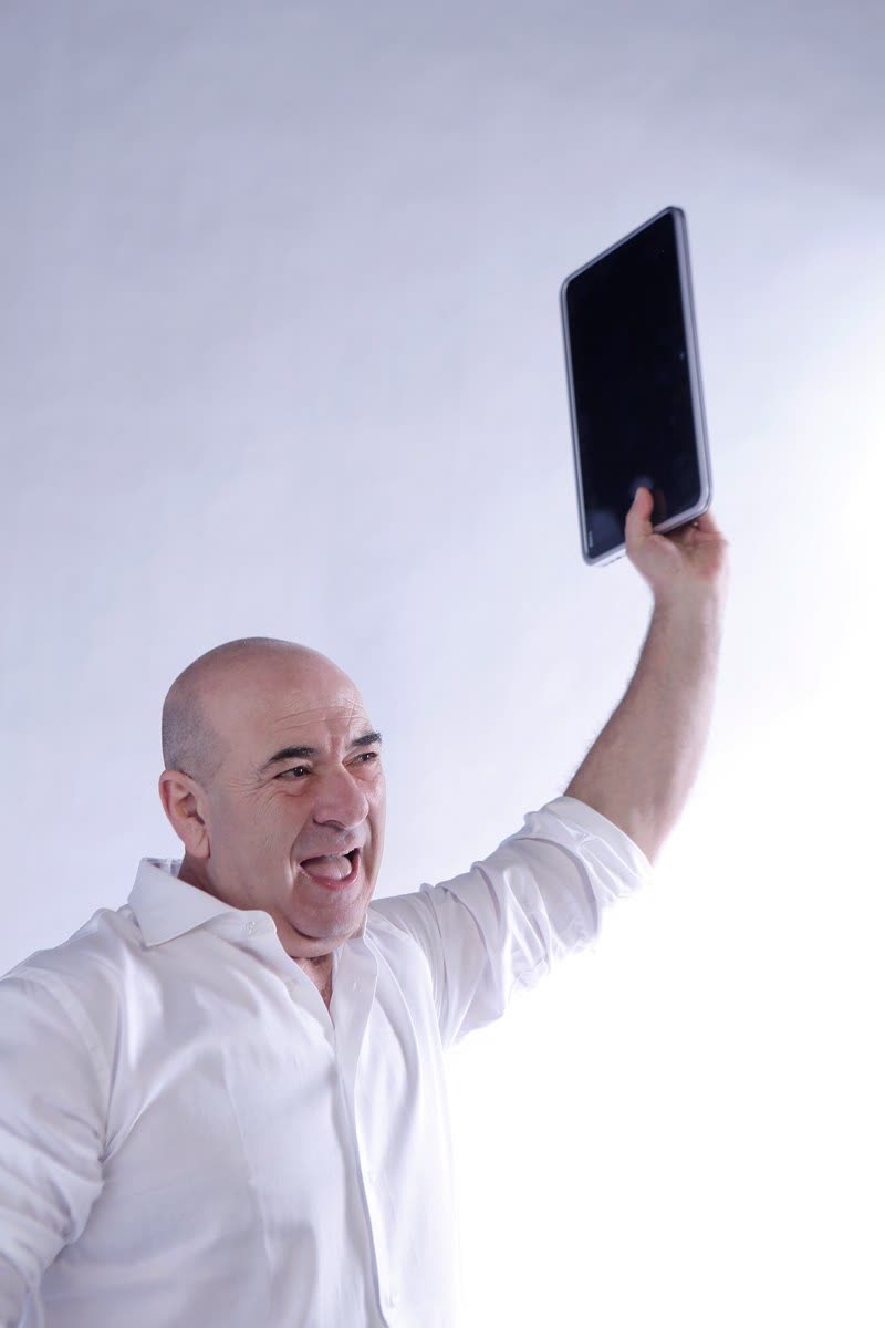 Mario solleva un tablet sopra la testa con espressione entusiasta