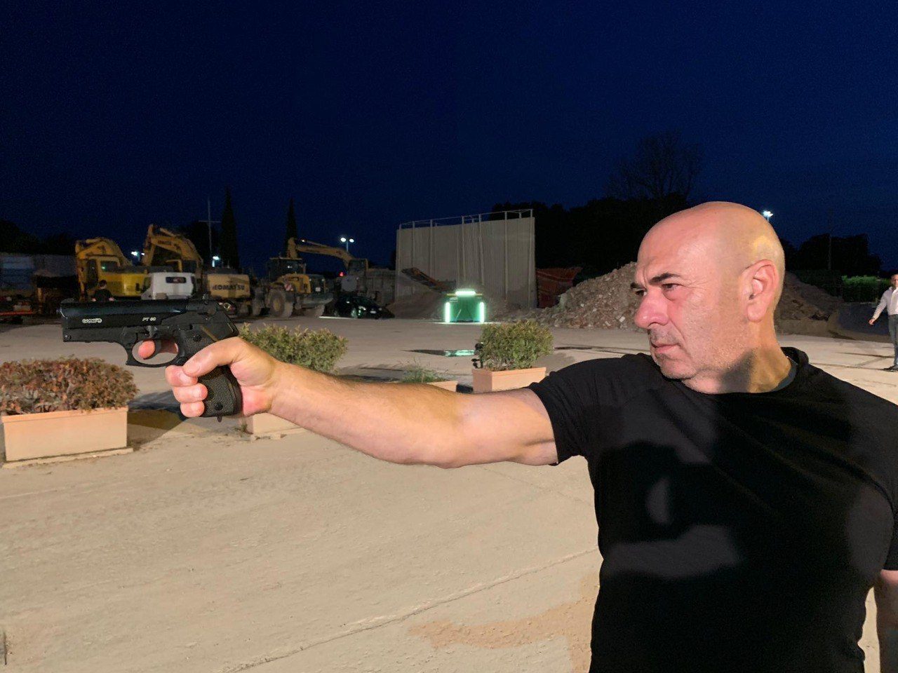 Mario De Filpo in scena di notte sul set del film ERIS, davanti a mezzi da cantiere